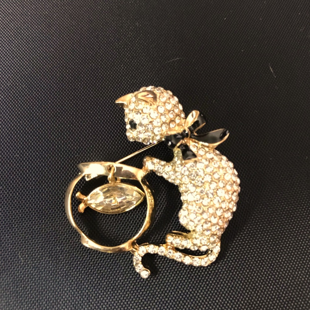Gold with sparkling clear rhinestones cat brooch. Black ribbon at cat’s neck.